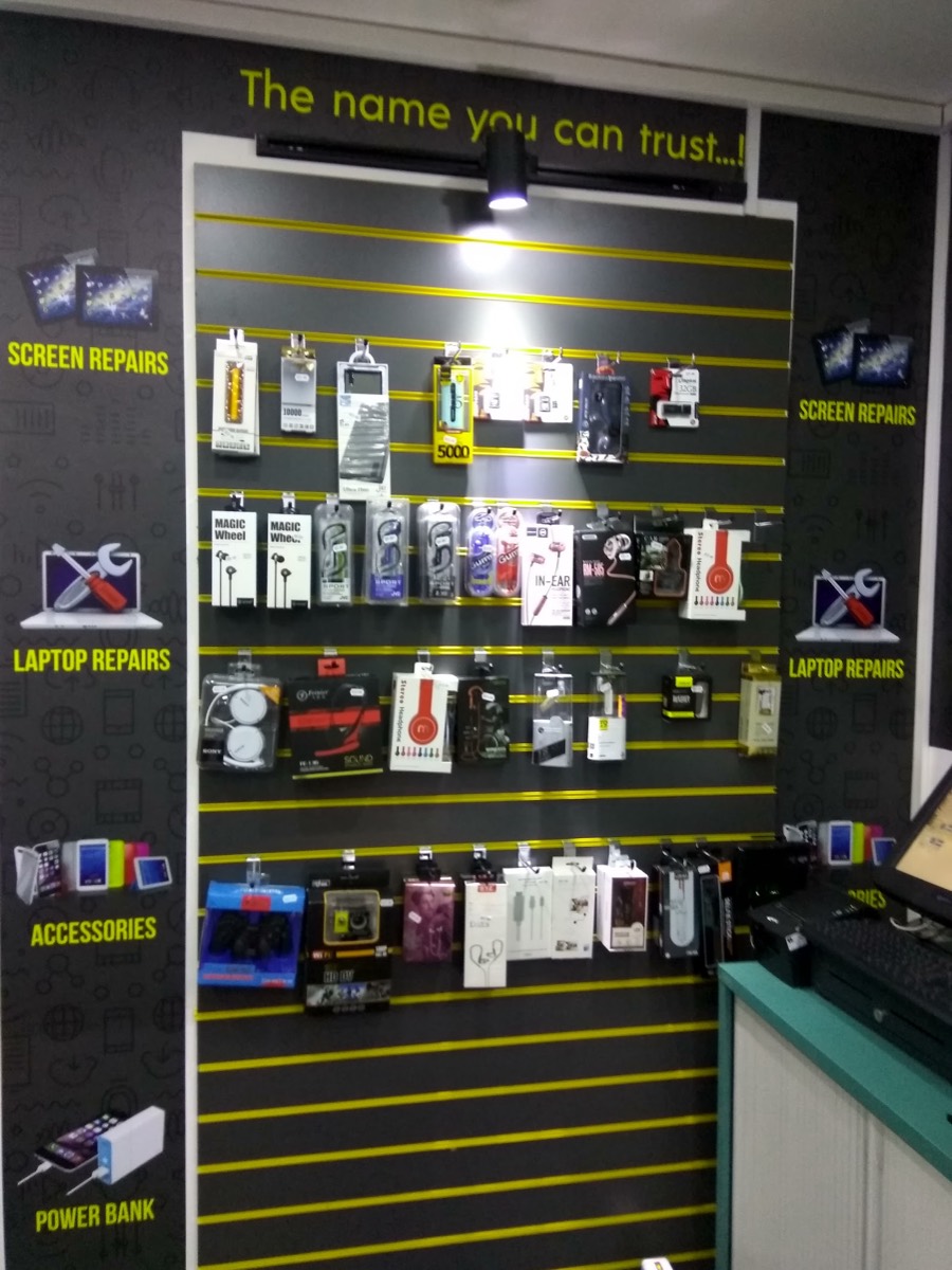 Inside World Phone Fix, a display wall of power banks, headphones and accessories under the shop slogan The name you can trust.